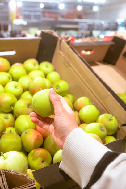istock hand taking apple from grocery store shelf 1753757572