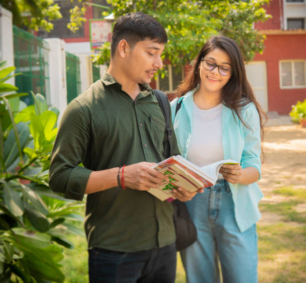istock University students reading a book together in a campus. 1753762060