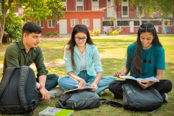 istock Students discussing together on a book in university campus ground. 1753762086