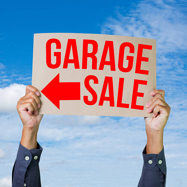 istock Two hands holding brown cardboard with garage sale 175376615