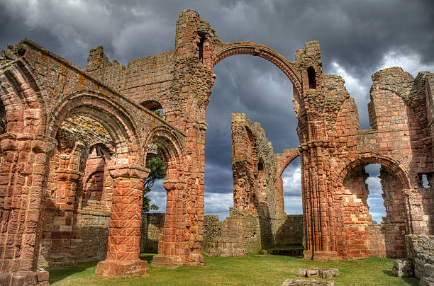 Lindisfarne Priory, Northumberland, after the storm Sunlight on the nave at Lindisfarne Priory church, just after a storm shower.  The priory was founded by St Aidan in AD635. lindisfarne monastery stock pictures, royalty-free photos & images