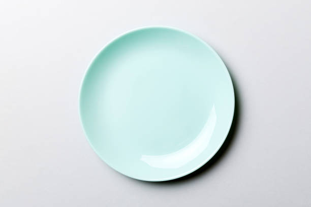 istock Top view of isolated of colored background empty round blue plate for food. Empty dish with space for your design 1753775673