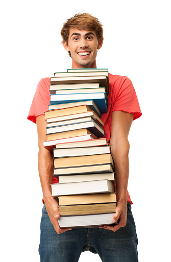 Portrait of happy young boy carrying stack of books. Vertical shot. Isolated on white.
