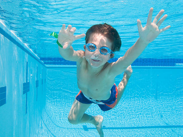 Boy Underwater In Swimming Pool With Arm Outstretched