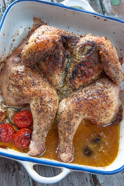 Freshly roasted spatchcock chicken in baking dish close up