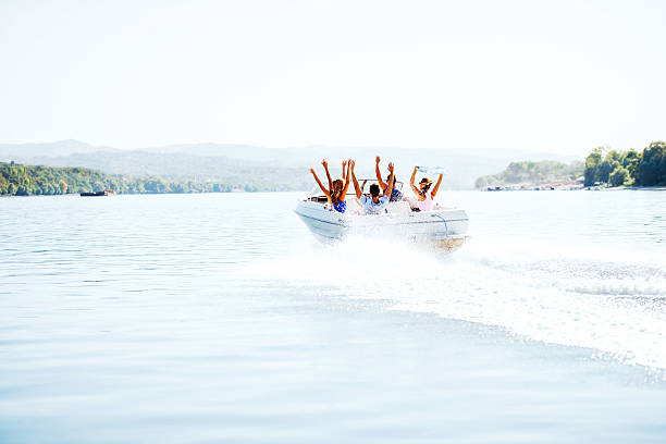 allegro giovani equitazione in un motoscafo. - speedboat leisure activity relaxation recreational boat foto e immagini stock