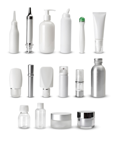 Mock-up of white plastic cosmetics bottles with skin care product on green background. Top view
