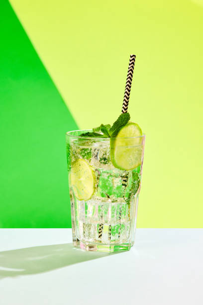 istock Poster. Lively lemonade with lime slices showcased against vibrant studio background in contemporary color scheme. 1753817801