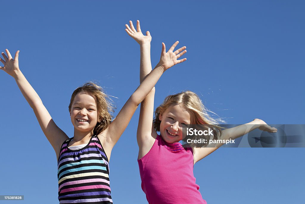 Deux filles heureuse avec les bras et ciel bleu - Photo de 8-9 ans libre de droits