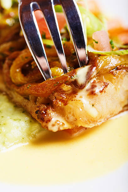 istock Fork pierces restaurant dish of grilled fish with cashew nuts 175383357