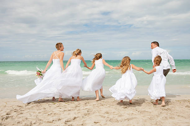 Beautiful couple with family on wedding day Beautiful couple on their wedding day in the beach with their four daughters at Varadero Cuba short weave hairstyles stock pictures, royalty-free photos & images
