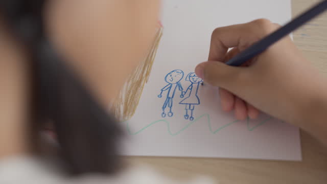 Close-up of a child hands coloring and drawing with a colored pencil