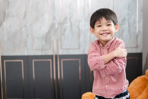 Photo of Asian boy standing with arms crossed smile happily
