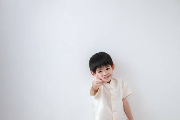 istock Asian boy Wearing traditional Thai clothing, standing with index finger forward. on a white background 1753847227