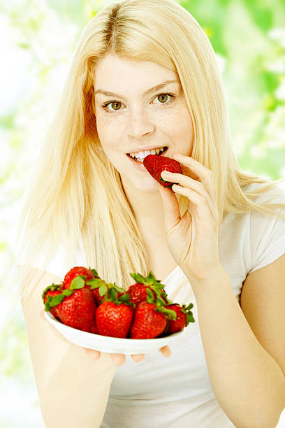 istock woman eating strawberry 175385707