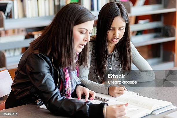 High School Student Tutors Niño De Primaria Niña En La Biblioteca Foto de stock y más banco de imágenes de 12-13 años