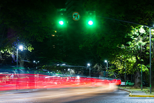 The traffic light is green and the cars pass by Av. Belgrano. Wide view of the avenue at night, on a long exposure photo. October 9, 2023. In the Rosario city, Santa Fe Argentina.