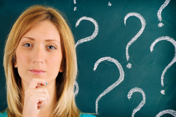 istock Pensive Woman in front of Question Marks Sketched on Blackboard 175386204