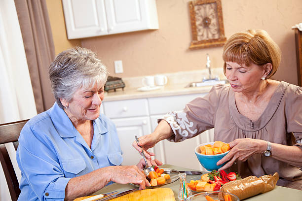 istock Two senior ladies preparing luncheon at kitchen table 175386459