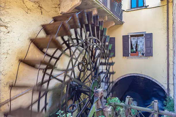 Watermill working in Borghetto downtown. Borghetto is a tiny, charming village on the banks of the river Mincio, built in 1400 around a series of water mills. It is situated along the beautiful bike path that connects the Lake Garda in Mantua, in the Regional Natural Park of River Mincio. Valeggio sul Mincio, Verona, Italy. Canon EOS 5D Mark II - blurred motion -