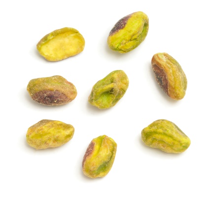 Eight shelled Pistachio nuts isolated on a white background.