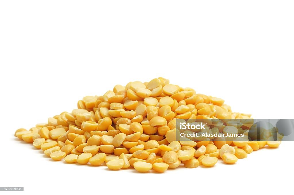 Yellow Split Peas A small heap of uncooked yellow split peas isolated on a white background. Yellow Stock Photo