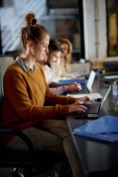 istock Young female programmer working on laptop late in the office. 1753875442