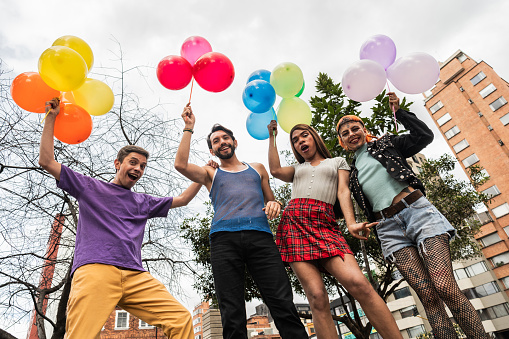 Portrait of lgbtqia+ people holding balloons outdoors