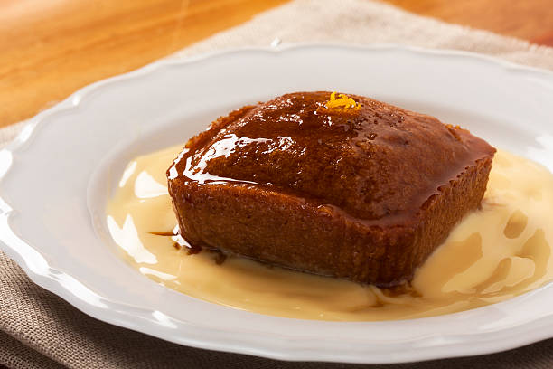 Malva pudding and custard Malva pudding. South African dessert. Spongy cake with a caramelized butter sauce. malva stock pictures, royalty-free photos & images