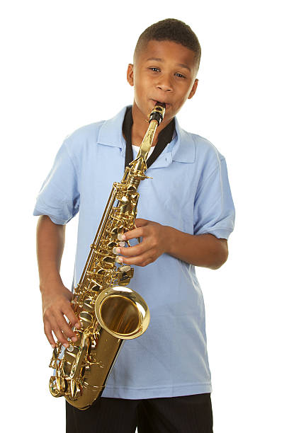 A handsome eleven year old African American boy playing the saxophone on a white background