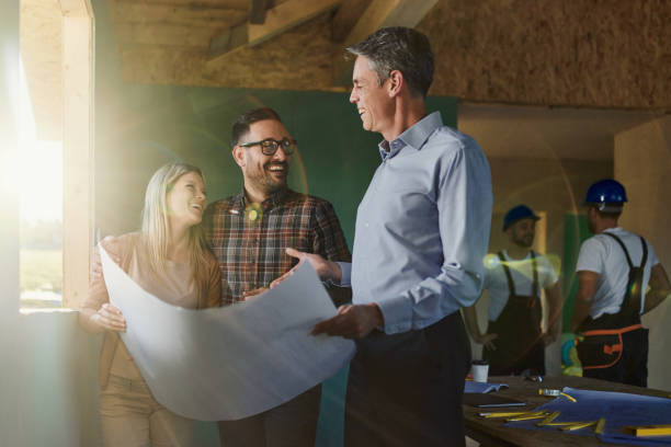 istock Happy couple talking about blueprints with architect at construction site. 1753882686