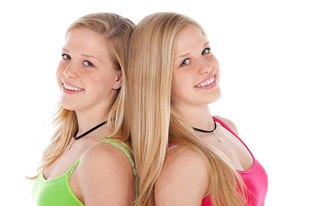 smiling young girl similar twins on white