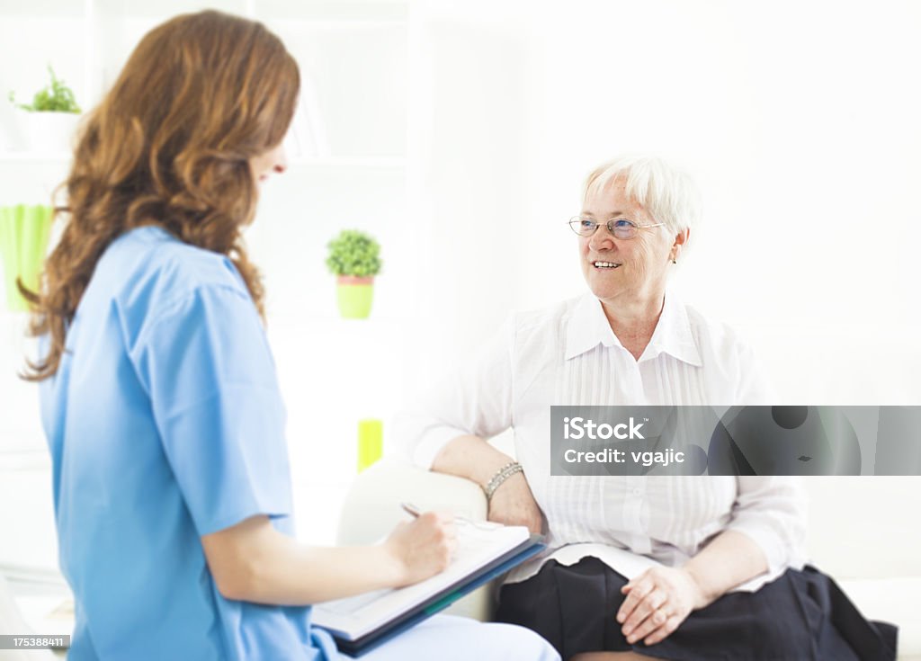 Doctor tomando notas de mujer Senior paciente. - Foto de stock de Paciente libre de derechos