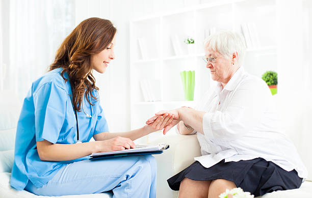 Doctor Checking Psoriasis on Senior Woman patient hand. Young female doctor examining psoriasis on hand of an senior woman patient in a doctor's office. Could be used also as Homeopathy Interview. Selective focus to senior woman. photo psoriasis stock pictures, royalty-free photos & images