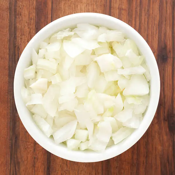 Top view of white bowl full of diced onions