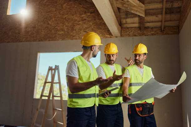 istock Team of manual workers talking about blueprints at construction site. 1753887776