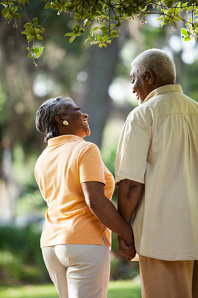 senior pareja afroamericana agarrar de la mano - couple mature adult action walking fotografías e imágenes de stock