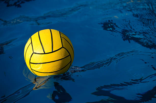 Water Polo Ball A yellow water polo balls rests in a water. water polo stock pictures, royalty-free photos & images