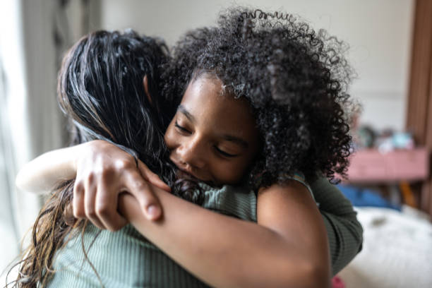 Mother and daughter embracing at home