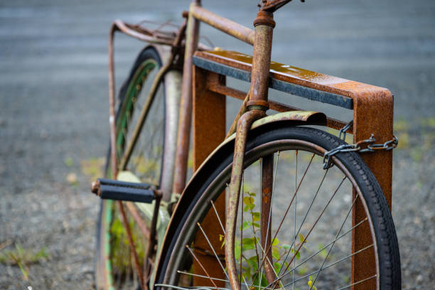 Old rusty bike chained to a bike rack.