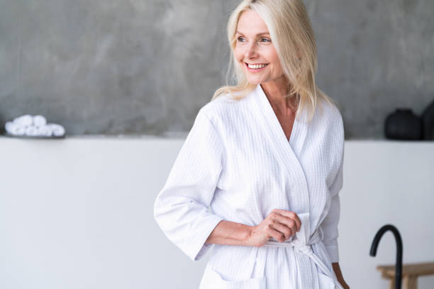 istock Mature woman in white bathrobe enjoy bath procedure 1753896122