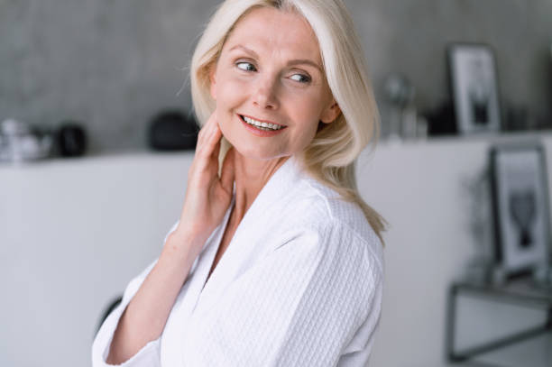 istock Mid aged woman look aside, touching her perfect smooth skin 1753896132
