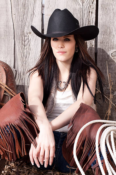 western cowgirl y saddle contra madera rústica valla - idaho beautiful western usa usa fotografías e imágenes de stock