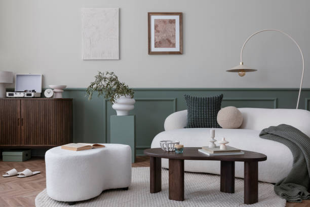 istock Creative composition of living room interior with mock up poster frame, boucle sofa, stylish lamp, round rug, wooden coffee table, sideboard, slippers and personal accessories. Home decor. Template. 1753896337