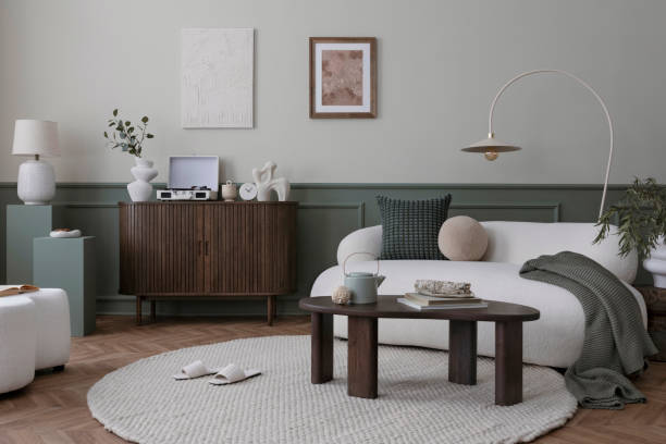 istock Creative composition of living room interior with mock up poster frame, boucle sofa, stylish lamp, round rug, wooden coffee table, sideboard, slippers and personal accessories. Home decor. Template. 1753896340
