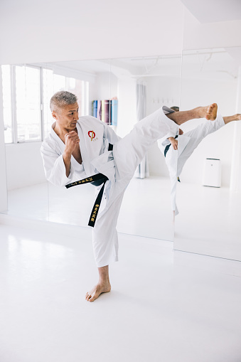 Japanese karate master focuses on perfecting his kicking techniques, demonstrating the spirit of lifelong growth in martial arts