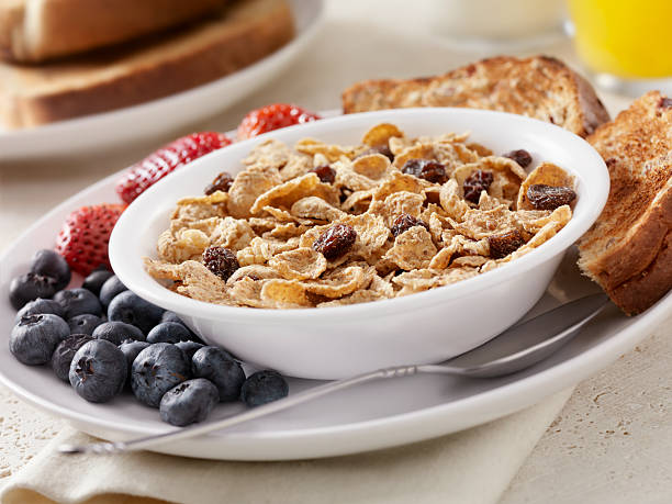 Raisin Bran "Raisin Bran Breakfast Cereal with Fresh Fruit, Whole Grain Bread, Milk and Orange Juice- Photographed on Hasselblad H3D2-39mb Camera" bran flakes stock pictures, royalty-free photos & images