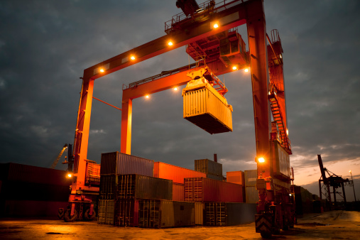 a container crane working after sunset with its lights onsimilar images: