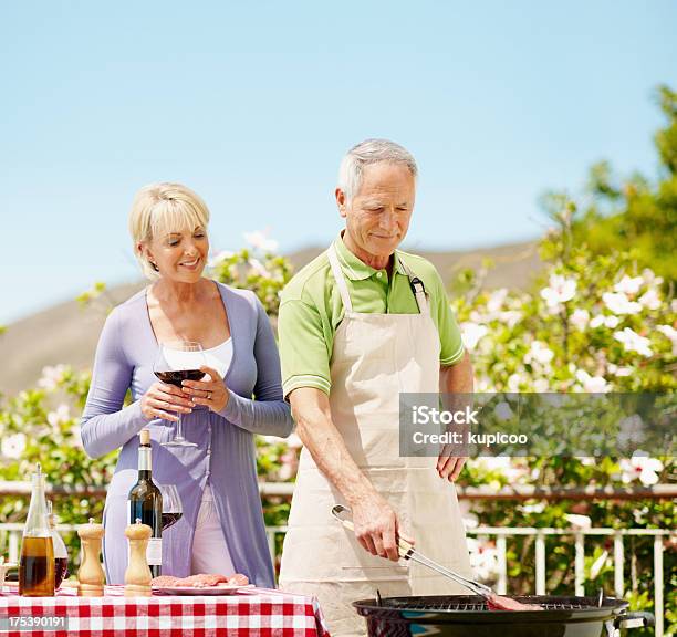 Photo libre de droit de Couple De Cuisson Sur Un Barbecue banque d'images et plus d'images libres de droit de Activité de loisirs - Activité de loisirs, Adulte, Adulte d'âge mûr