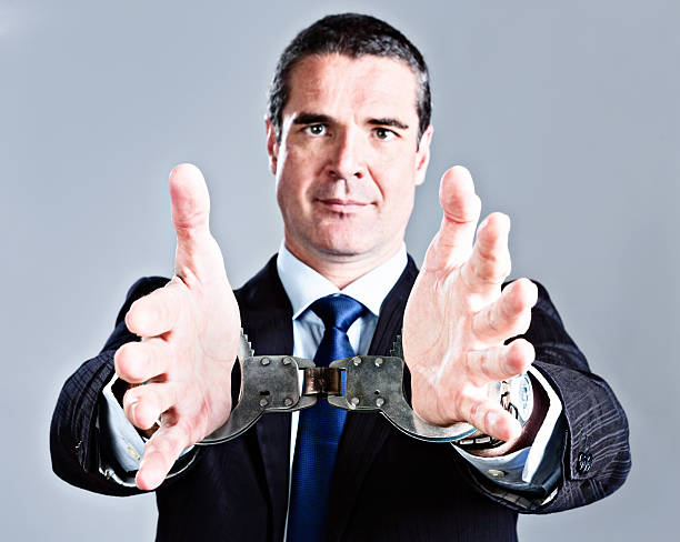 przystojny biznesmen dociera z handcuffed ręce - re2012019 zdjęcia i obrazy z banku zdjęć